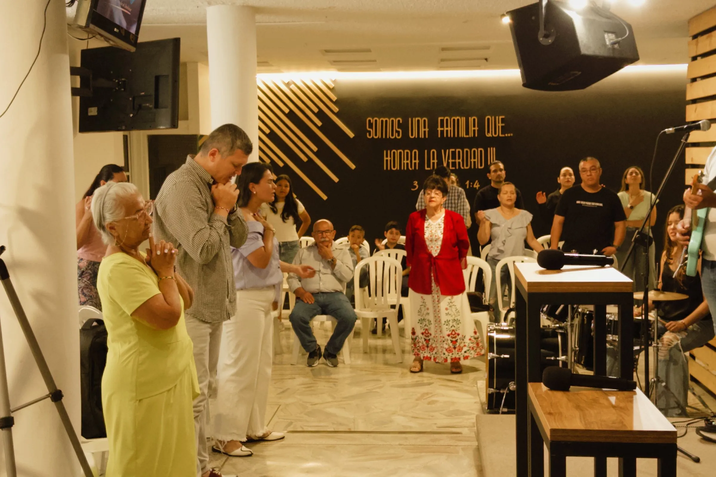 Familia de La Casa del Padre orando juntos en el servicio
